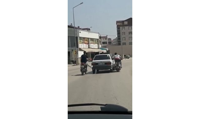 Bursa'da motosiklet sürücüleri yolda kalan otomobili ayaklarıyla ittiler