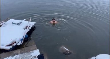 Boğazları yüzerek geçen sporcu, karlı havada Devegeçidi Barajı'na girdi