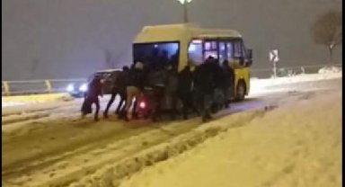 Karda yokuşu çıkamayan minibüsü yolcular itti