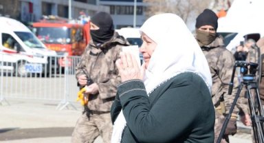 Kendisini kurtaran ekipteki özel harekat polisine sarılıp, gözyaşlarıyla enkazı izledi