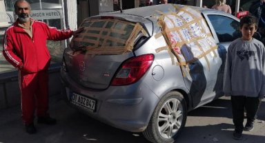 Otomobilinin depremde kırılan camlarını naylon ve çuvalla kapatıp Hatay'dan Mersin'e geldi