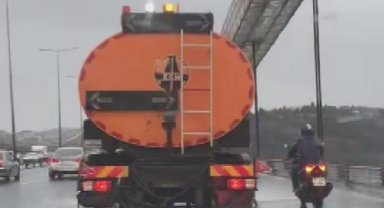 Şiddetli rüzgarda köprüden geçmeye çalışan motosikletliye kalkan oldu