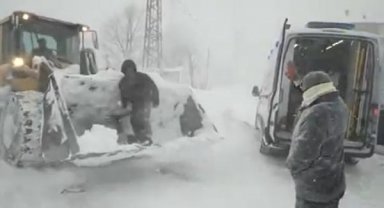 Yolu kardan kapanan mahallede rahatsızlandı, kepçeyle ambulansa taşındı