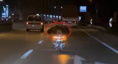 Plakasını kapattığı motosikletinin üzerine yüzüstü yatıp, trafikte ilerledi