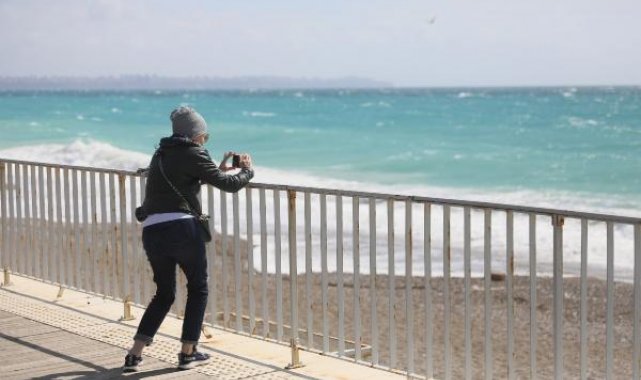 Rüzgarlı havada sahilde dalgalarla fotoğraf çektirdiler