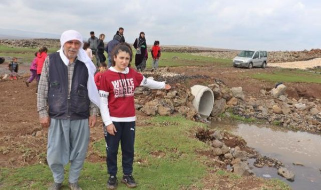 Sağanakta köprü yıkılınca, öğrencileri derenin diğer tarafına sırtlarında taşıyarak geçirdiler