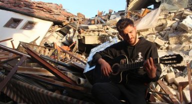 Deprem öncesi müzik yaptığı sokakta, bu kez enkaz önünde 'Hatıran Yeter' şarkısını söyledi
