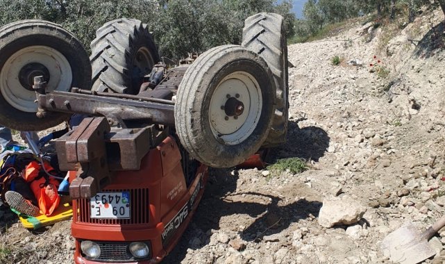Devrilen traktörün altından yardım istedi