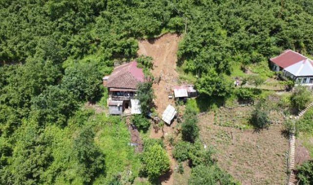 Anne ve oğlu, heyelanda hasar gören evlerinin penceresinden çıkmış