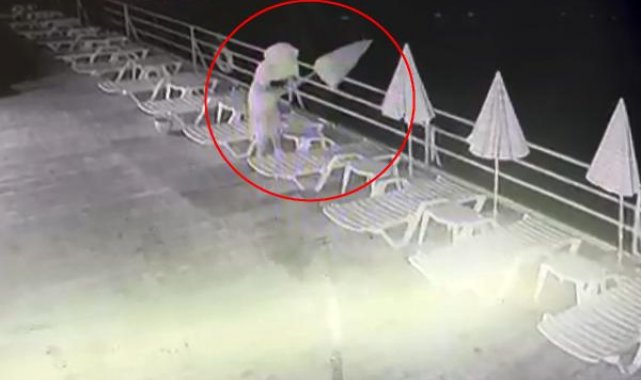 Havluyla yüzünü gizleyip dans etti, ardından plaj şemsiyelerini denize attı