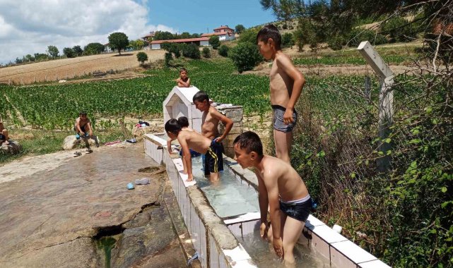 Sıcaktan bunalan çocuklar yalakta serinledi