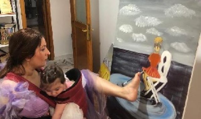 İki kolu da olmayan Ayşe, sol ayak parmağıyla resim yapıyor