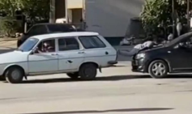 Arıza yapan otomobili, arkadaki otomobilin üzerine yatan çocukla ittiler