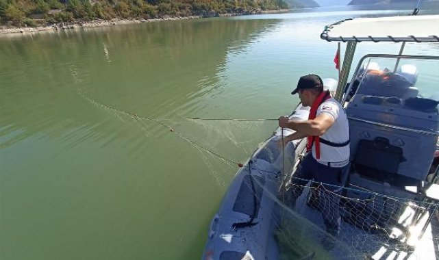 Baraj gölüne serilen sahipsiz ağa takılan 200 kilo canlı balık kurtarılarak suya bırakıldı