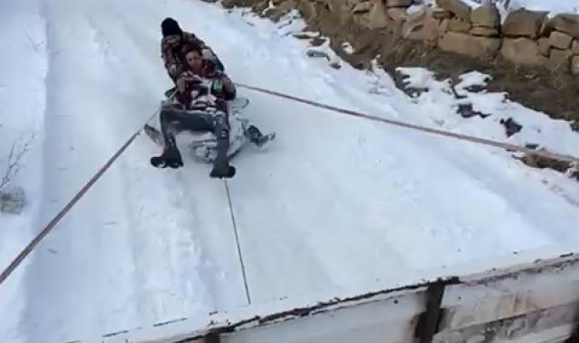 Kamyonet arkasına bağladıkları tekerlekle karda kaymanın keyfini yaşadılar