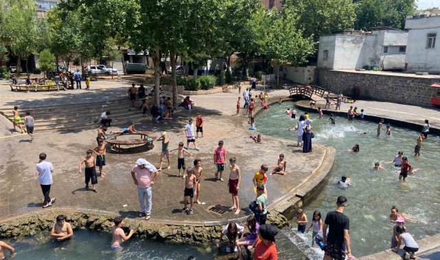 Diyarbakır'da çocuklar ailelerinin nezaretinde süs havuzunda serinliyor