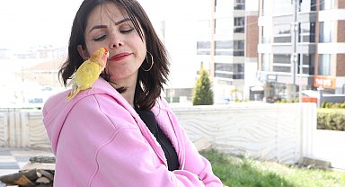 Sahiplendiği papağanını yanından ayırmıyor