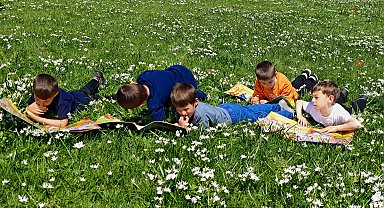 İlkokul öğrencileri yaylada rengarenk çiçekler arasında kitap okudu