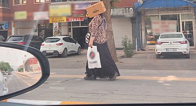 Başına karton kutu geçirerek sıcaktan korunmaya çalıştı