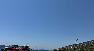 Bodrum'da kayalıklara sürttükten sonra karaya oturan yelkenli için kurtarma çalışması