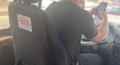 Dolmuş şoförü, direksiyon başında telefonla oynayıp sigara içti