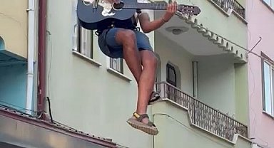 Eşyalarını taşıdığı halatın üzerinde gitar çalıp, şarkı söyledi