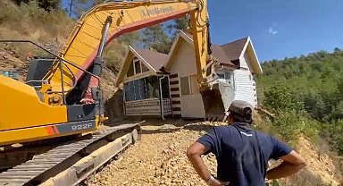Yıkım kararı verilen konteyner evini iş makinesiyle karadan rayla yürütüp taşıdı
