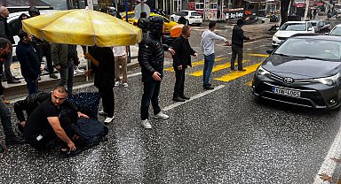 Esnaf, kazada yaralanan yaya ıslanmasın diye şemsiye açtı, üstüne mont örttü