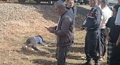 Torununu trenin altında kalmaktan kurtardı, kendisi ağır yaralandı