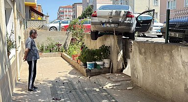 El freni çekilmeyen otomobil, hareket edip istinat duvarında asılı kaldı