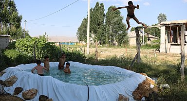 Sıcaktan bunalan çocuklar, brandayla oluşturulan havuzda serinliyor