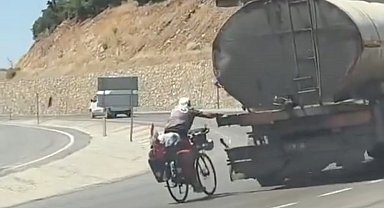 Tankere tutunup yolculuk yapan bisikletli kamerada