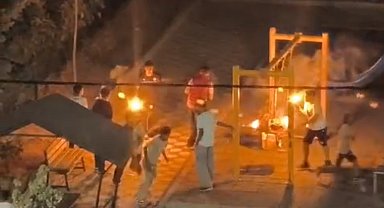 Tutuşturdukları sopalarla parktaki çocukları korkuttular